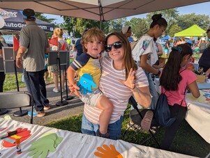 a woman holding a child under a tent
