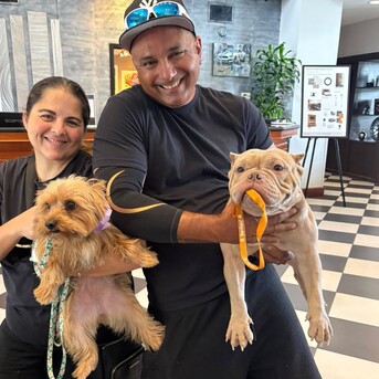a man and woman holding dogs