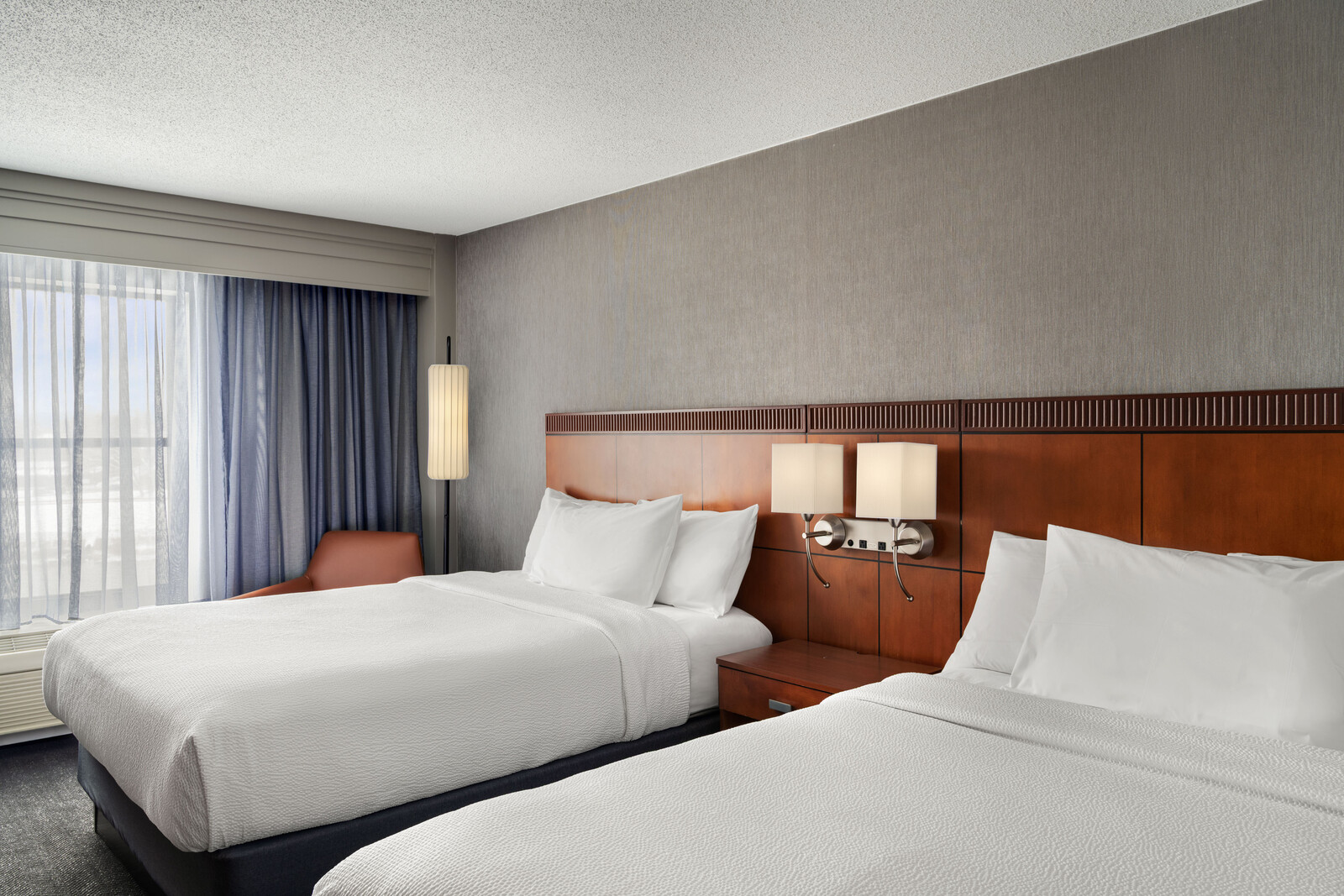 a room with two beds and a lamp