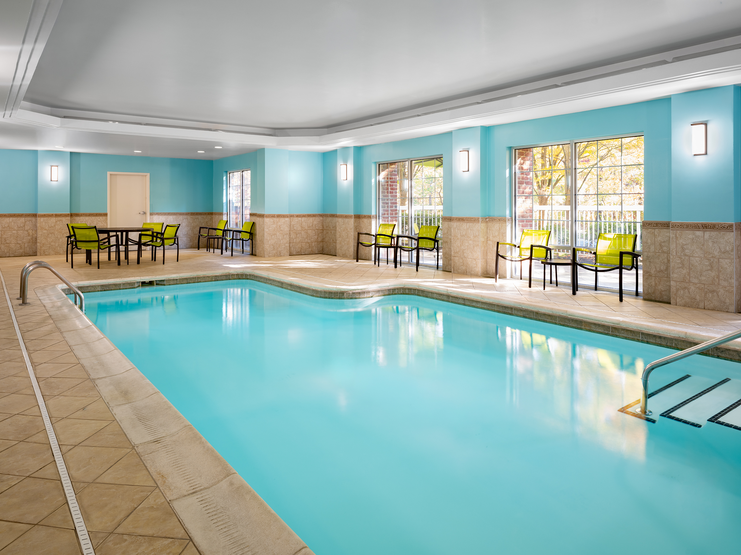 a indoor swimming pool with chairs and tables