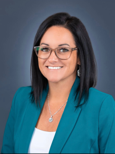 a woman wearing glasses and a blue jacket