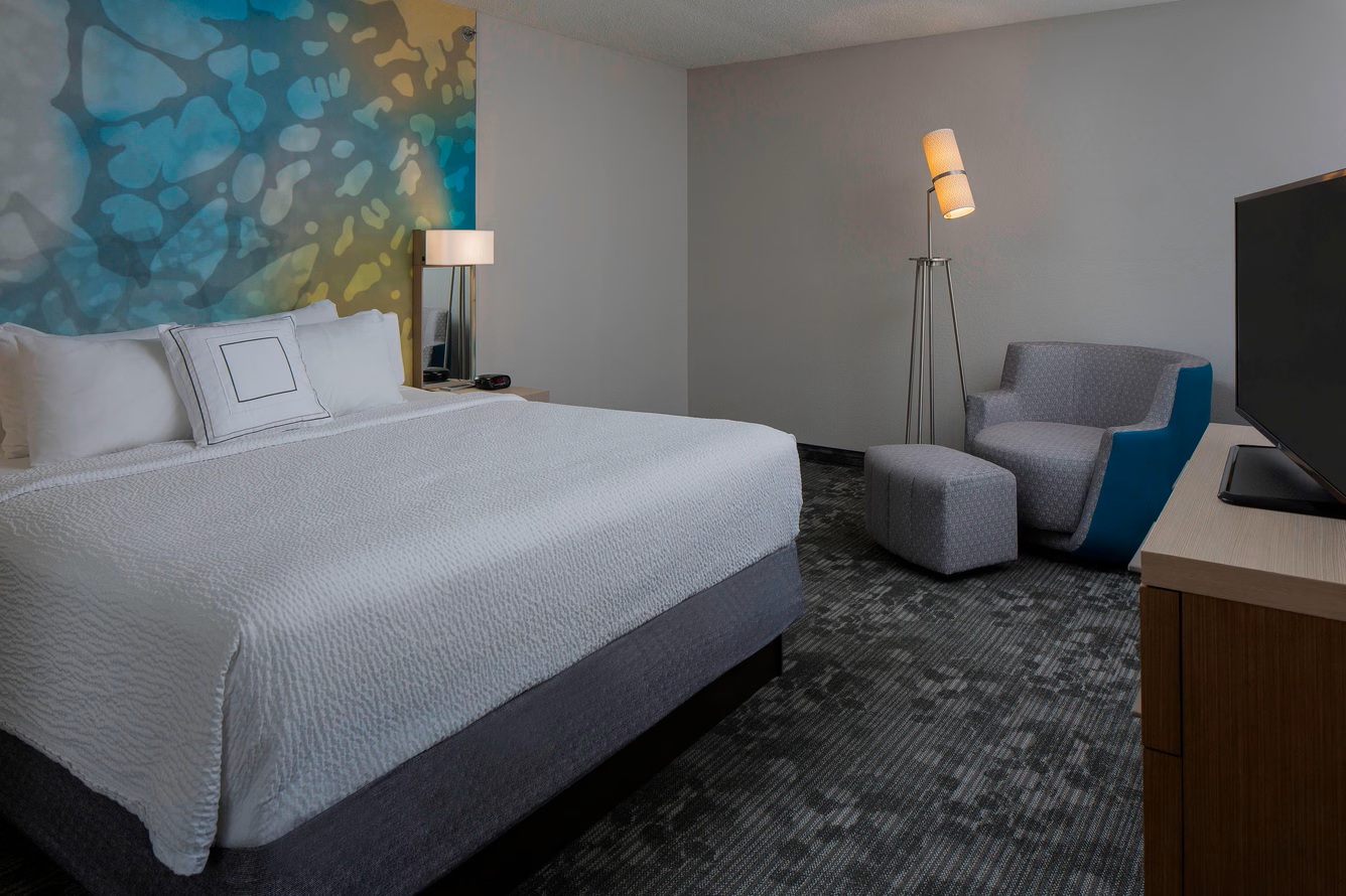 a hotel room with a bed and a chair
